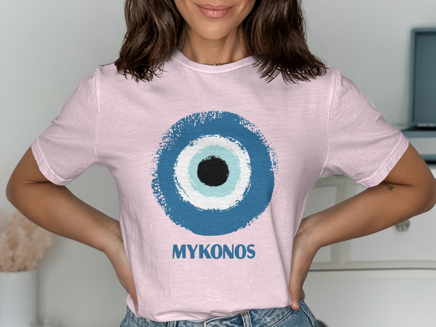 Pink t-shirt with a blue and white evil eye graphic and "MYKONOS" text.
