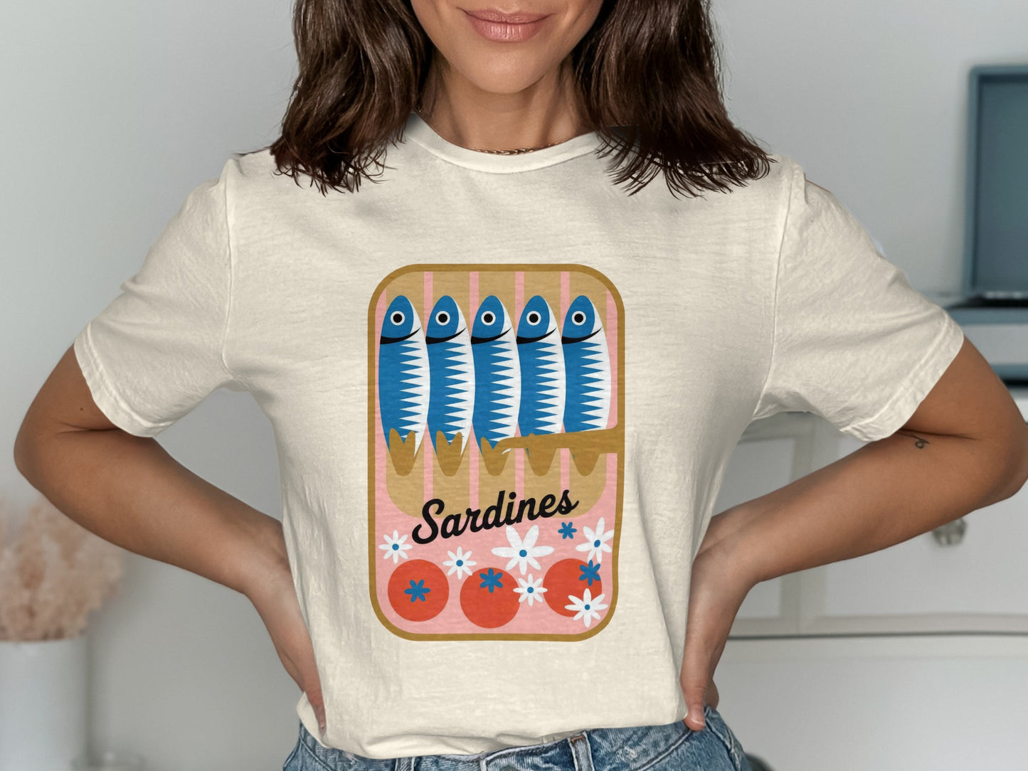 Cream t-shirt with a cartoon illustration of sardines in a can.
