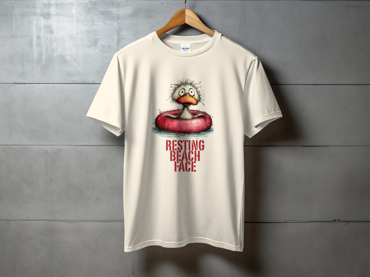 Cream t-shirt with a cartoon duck wearing a red inner tube, text reads "RESTING BEACH FACE".