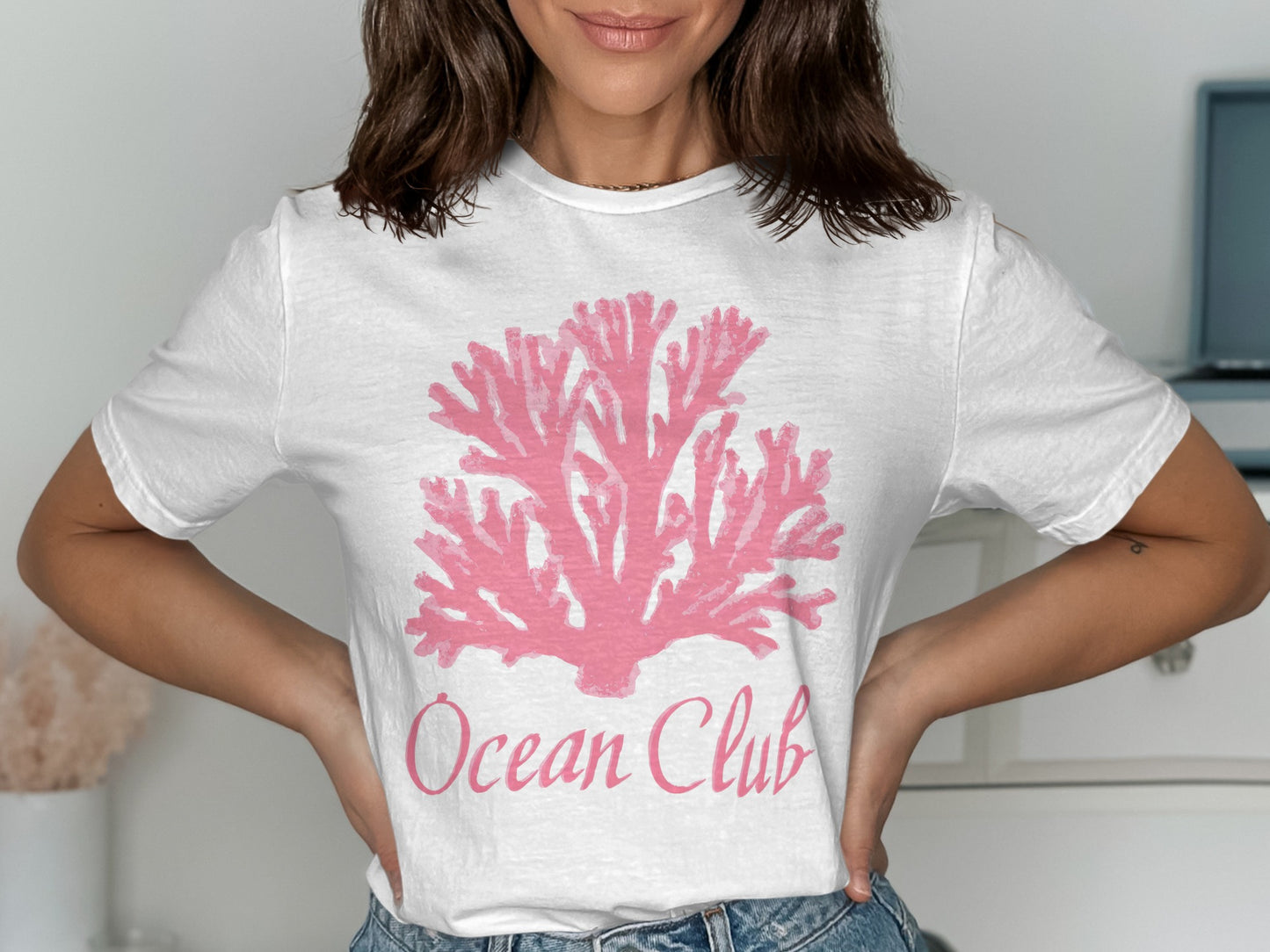 White t-shirt with pink coral graphic and "Ocean Club" text.