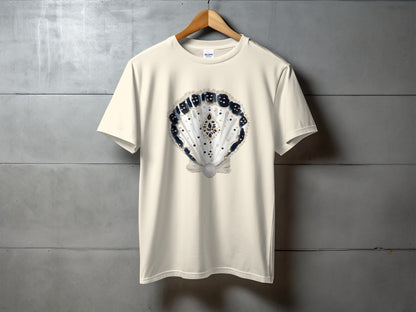 Cream t-shirt with a seashell graphic featuring dice and a pearl.
