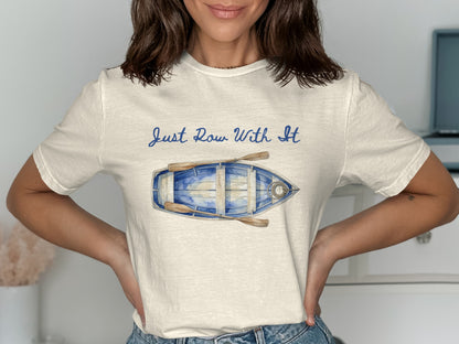 White t-shirt with a watercolor painting of a rowboat and oars and text "Just Row With It".