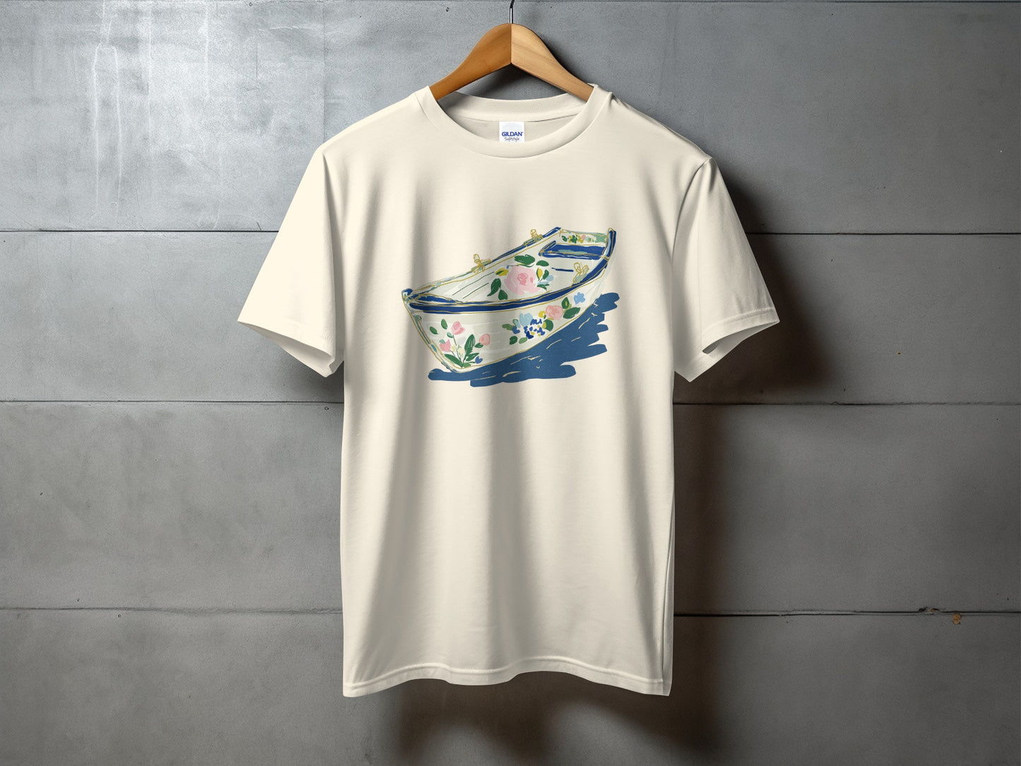 Cream t-shirt with a floral rowboat graphic and blue shadow.