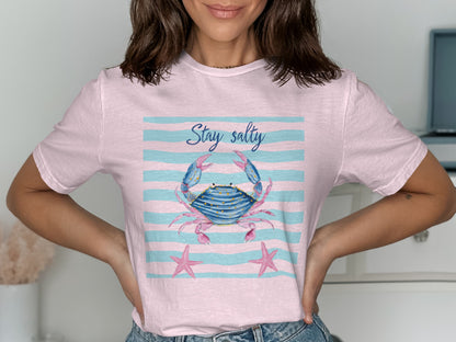 Pink t-shirt with blue stripes, a crab, and starfish, reads "Stay Salty".