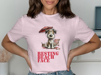 Pink t-shirt with cartoon dog on beach chair, text "RESTING BEACH FACE".