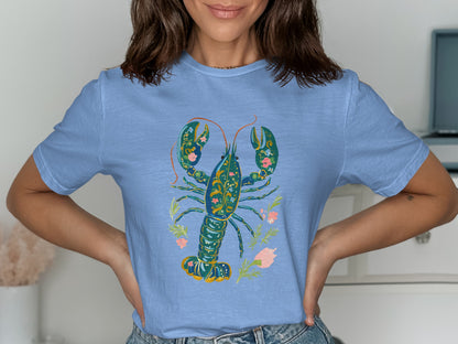 Blue t-shirt with a decorative teal lobster and pink floral design.