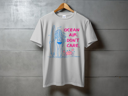 White t-shirt with "Ocean Air Don't Care" text, a surfer, and a crab graphic.