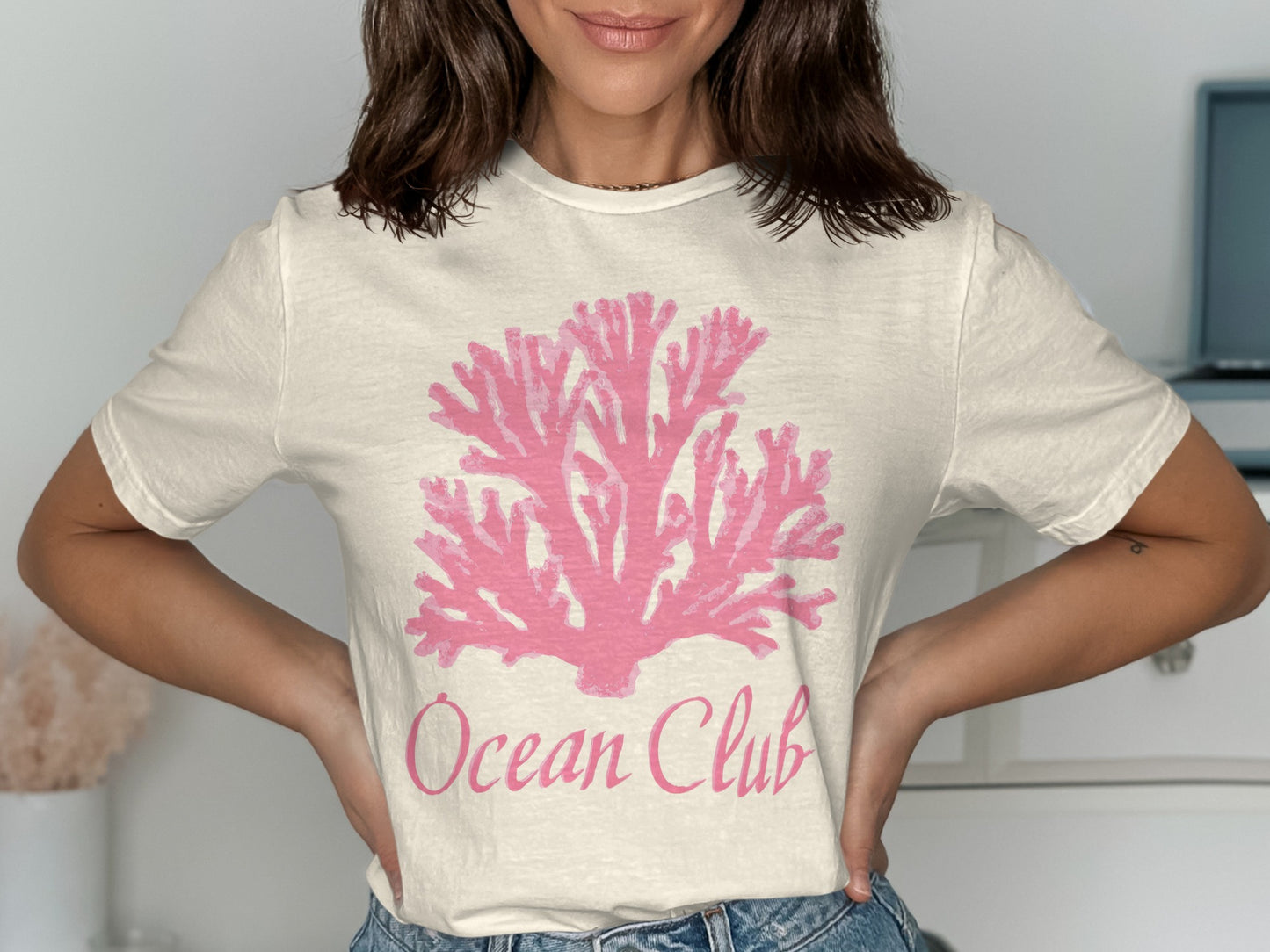 White t-shirt with pink coral graphic and "Ocean Club" text.