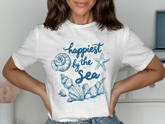 White t-shirt with blue "Happiest by the Sea" text and ocean shell graphics.