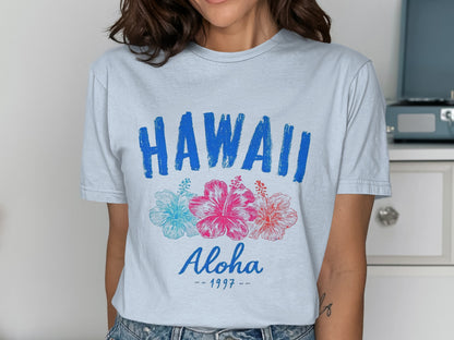 Light blue t-shirt with "HAWAII ALOHA 1997" and three hibiscus flowers.