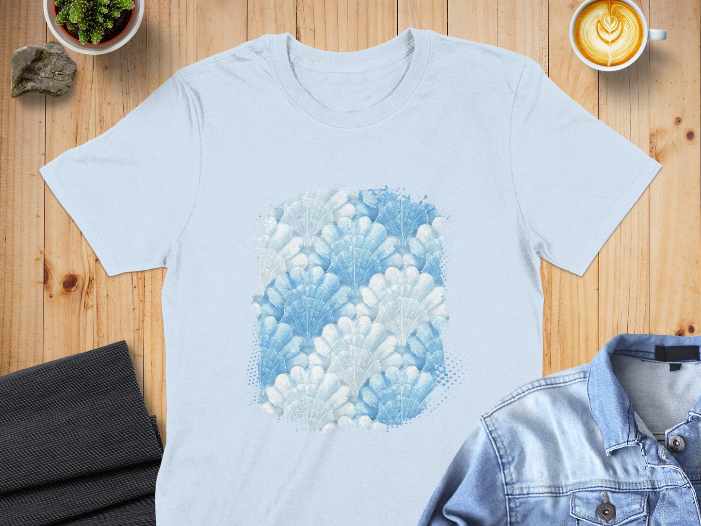 Light blue t-shirt with a repeating pattern of blue and white fan-shaped motifs.