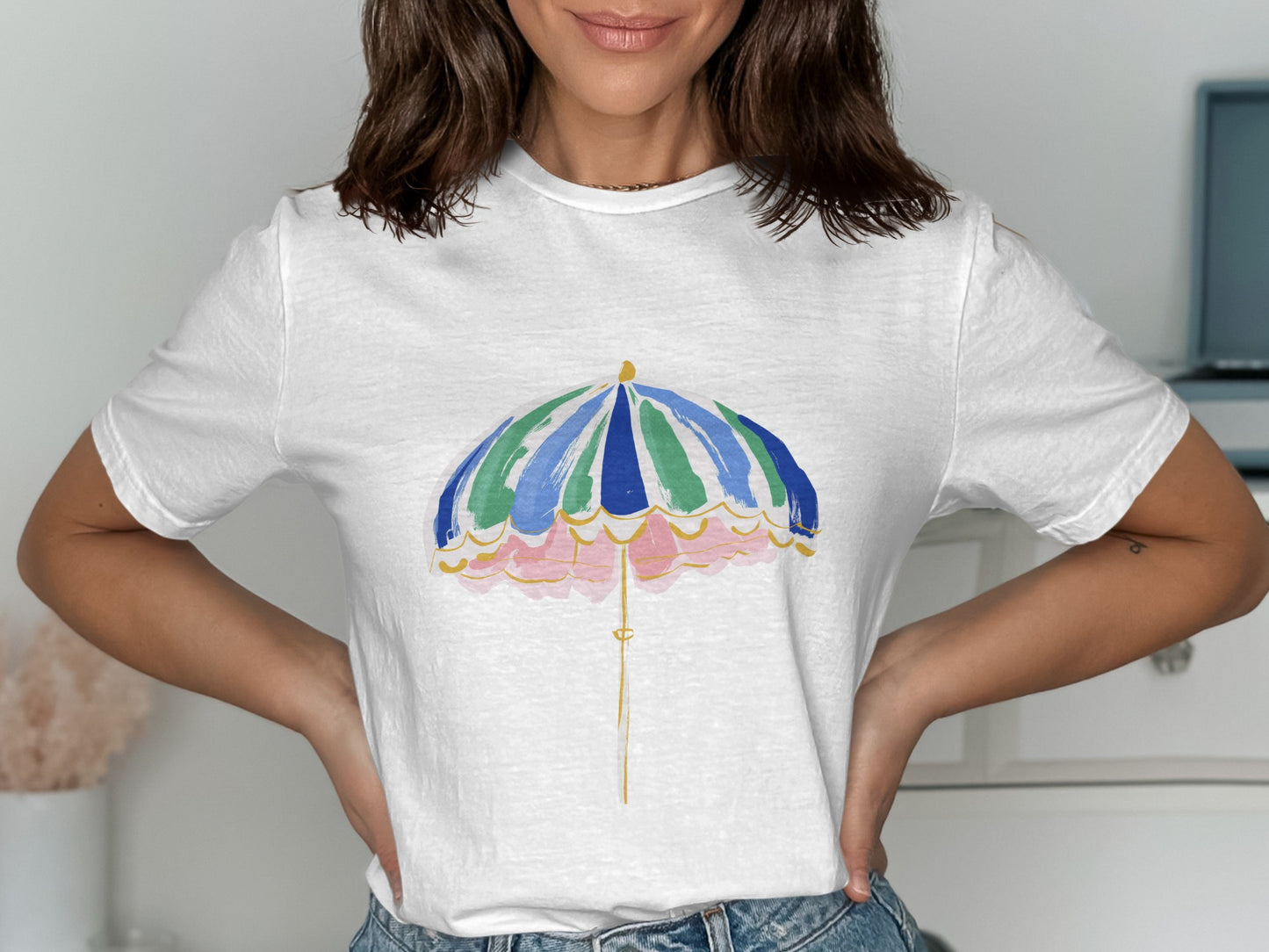 White t-shirt with a colorful umbrella graphic and scalloped pink border.
