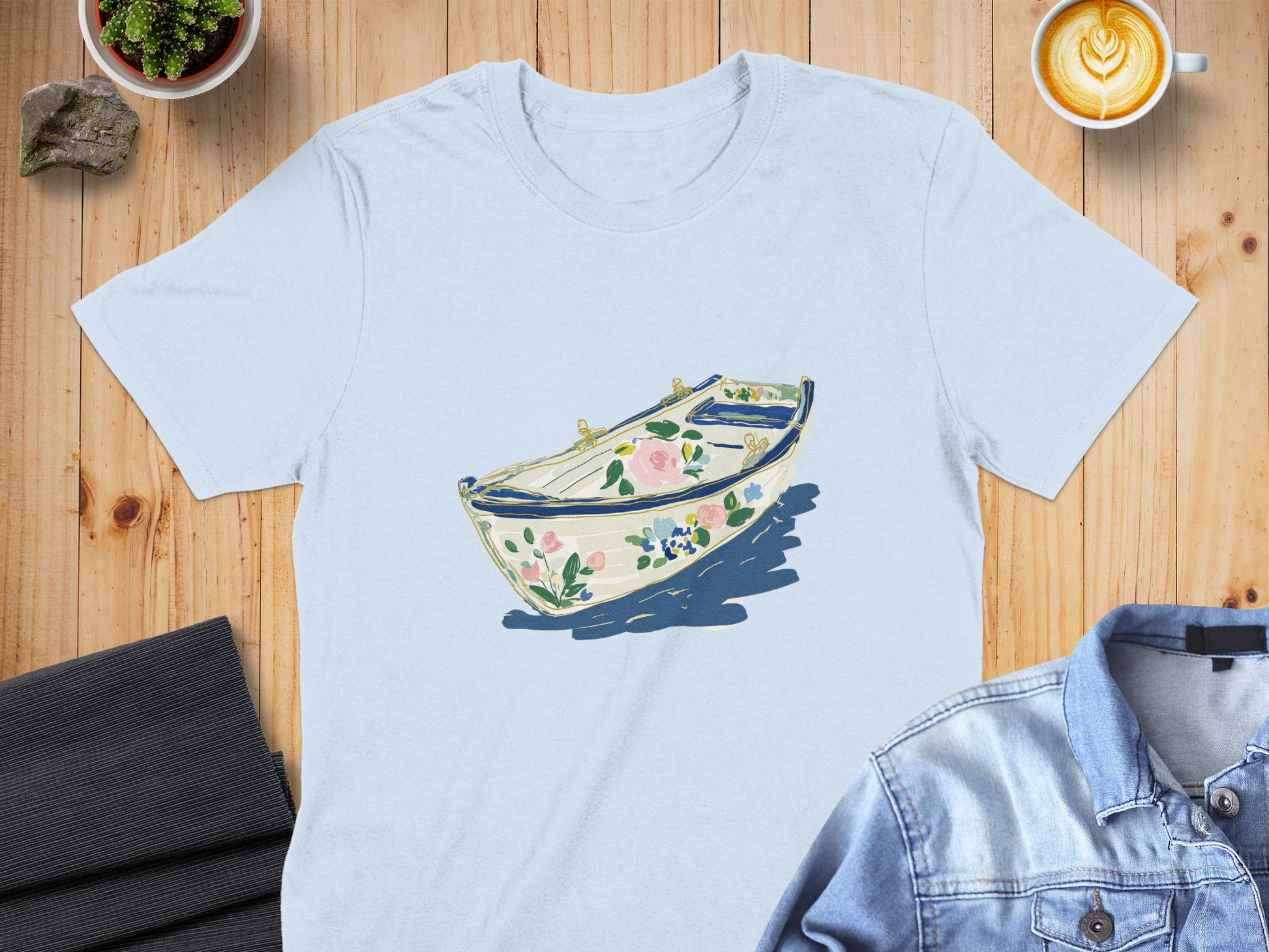 Light blue t-shirt with a floral boat illustration.