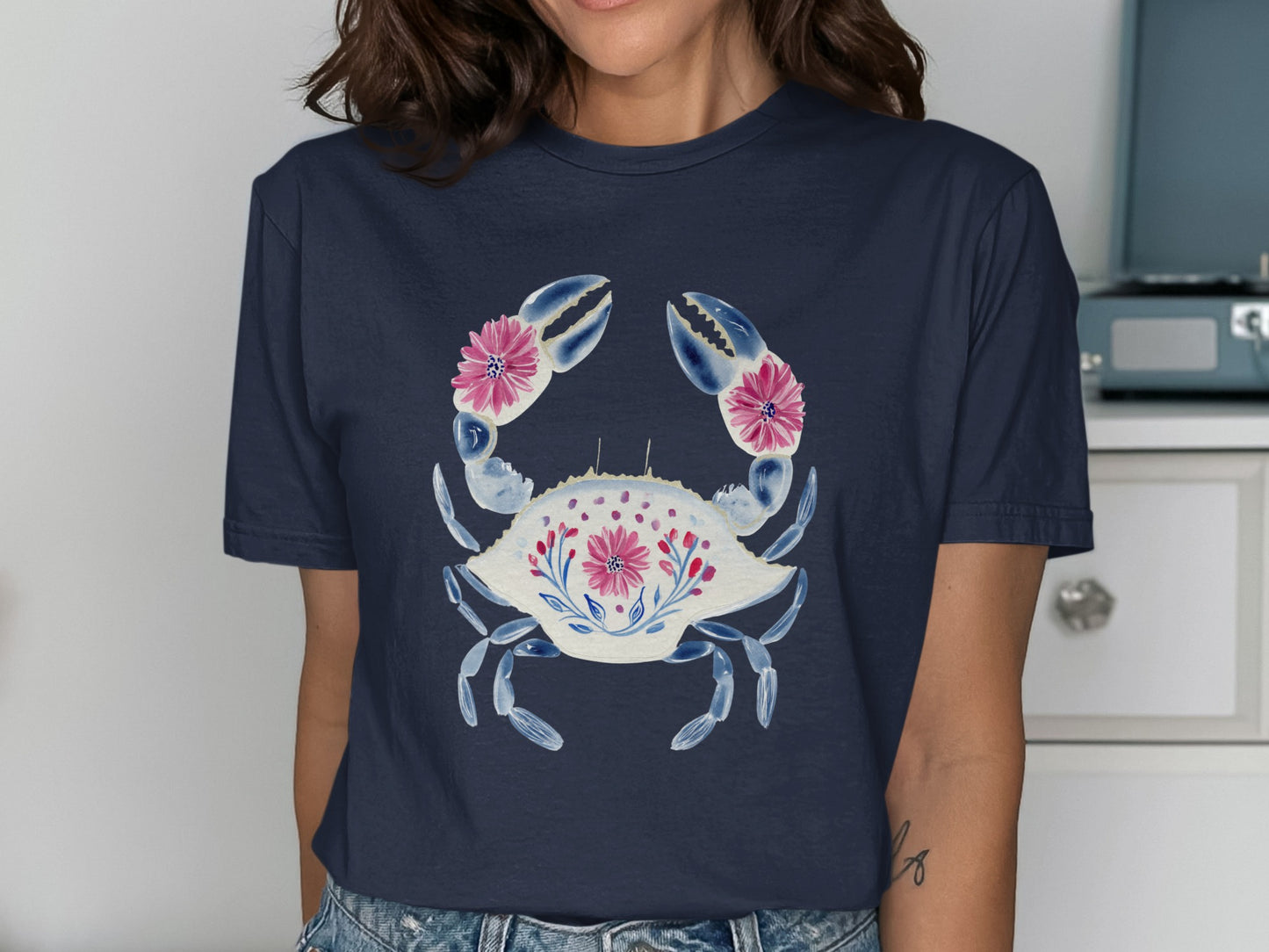 Navy t-shirt with a white crab design and pink floral accents.