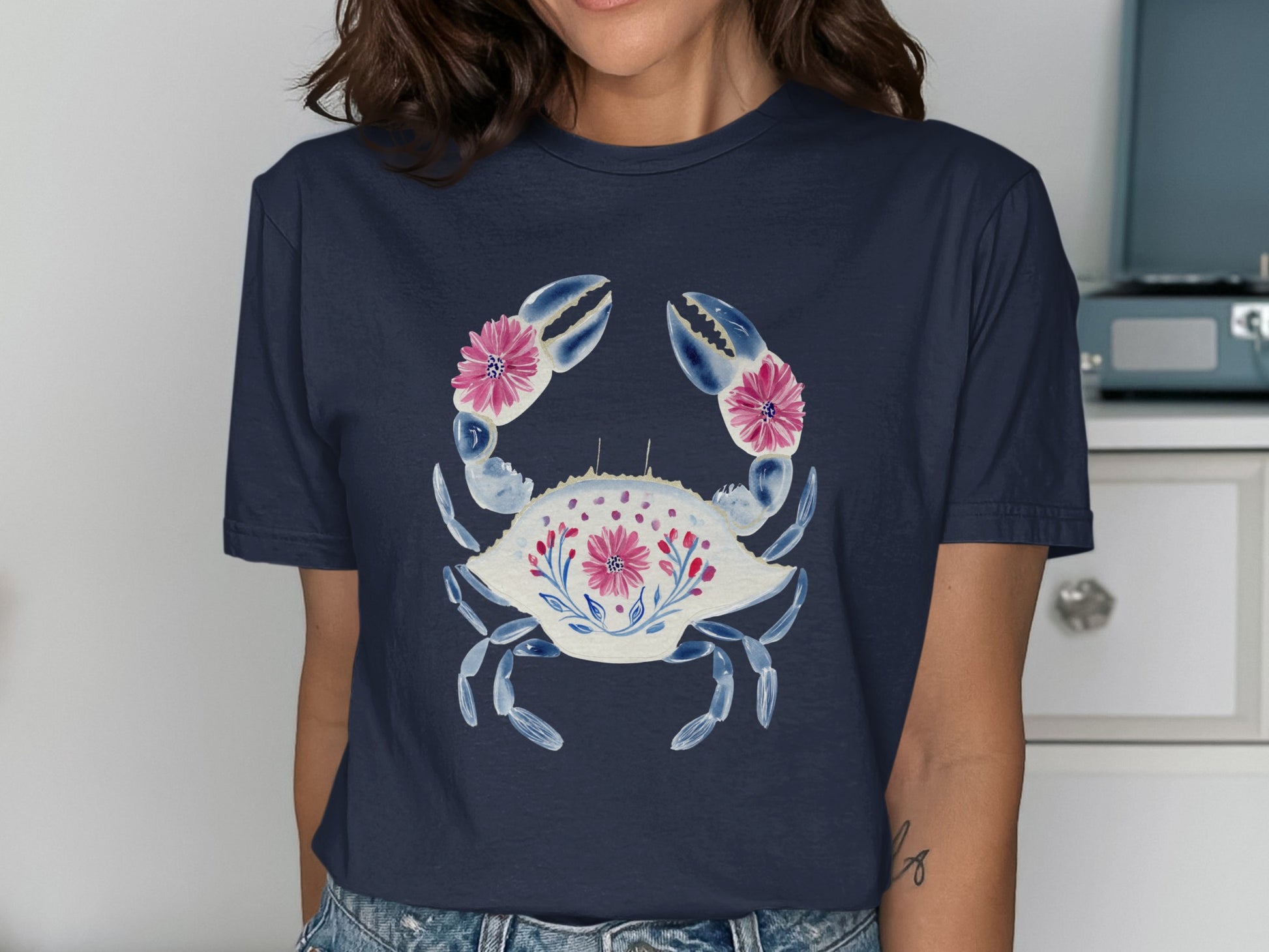 Navy t-shirt with a white crab design and pink floral accents.