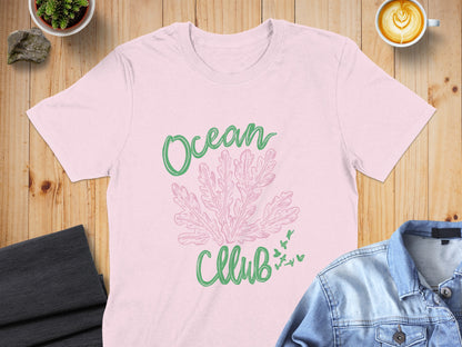 Pink t-shirt with green "Ocean Club" text and coral illustration.