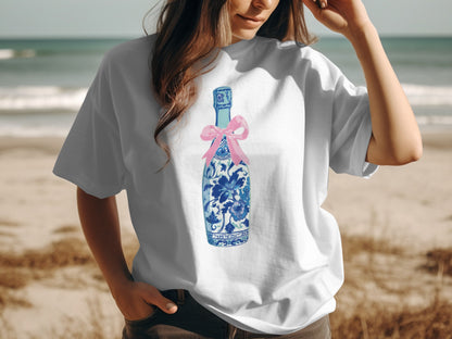 White t-shirt with blue floral bottle and pink bow graphic.