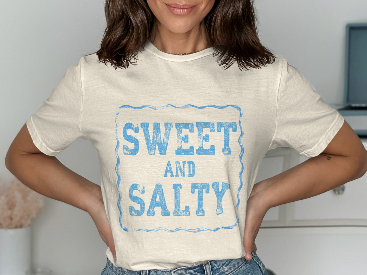 Cream t-shirt with blue "SWEET AND SALTY" text in distressed font.