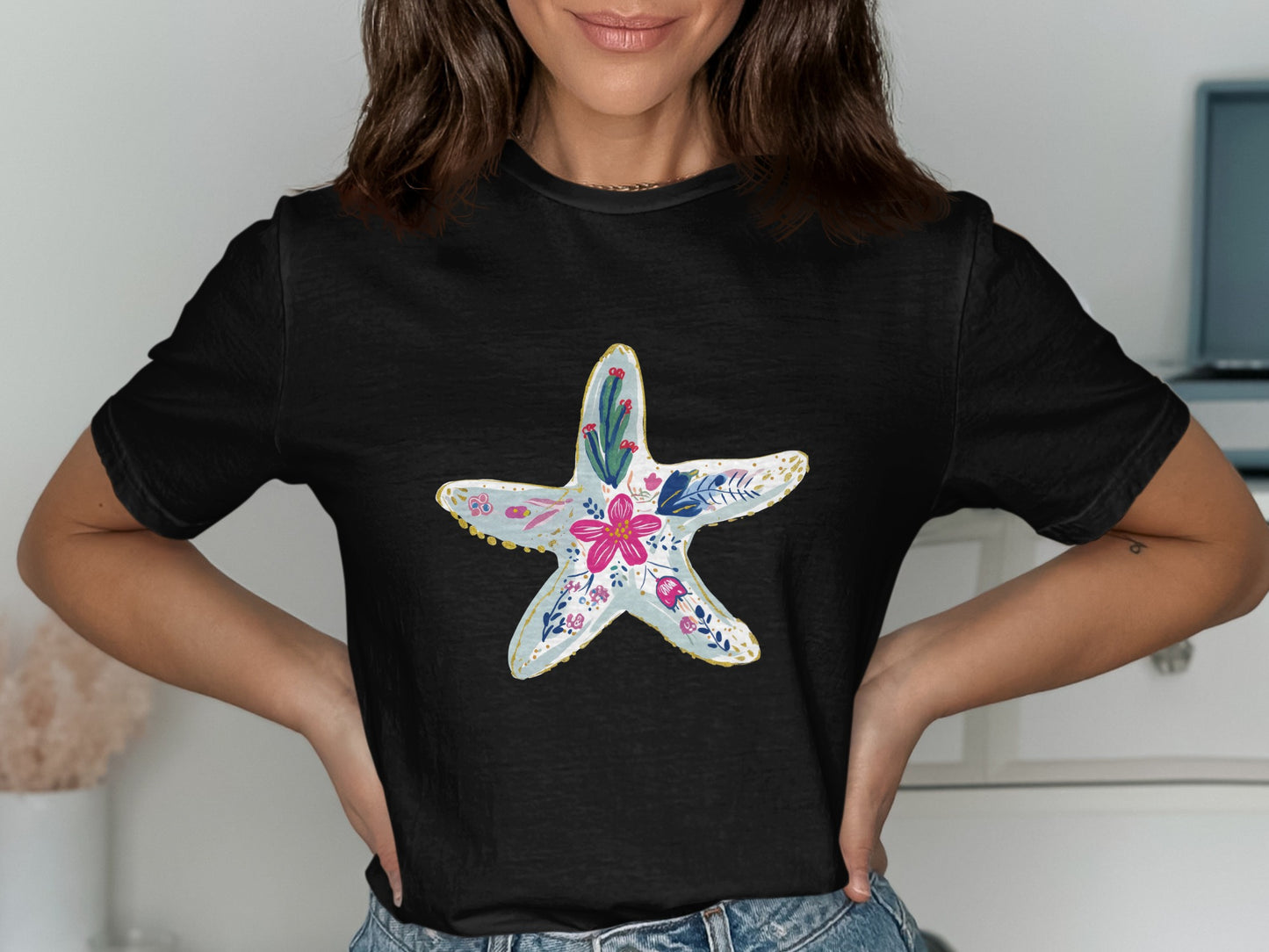 Black t-shirt with a light blue starfish design featuring pink and white floral accents.
