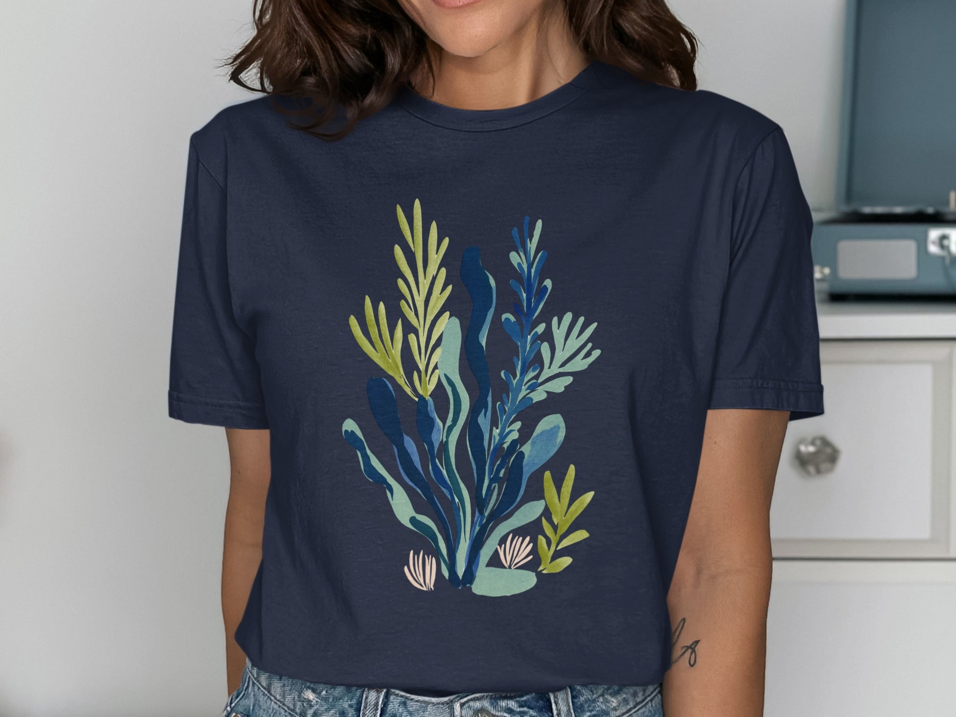 Navy t-shirt with a colorful botanical illustration of seaweed and coral.