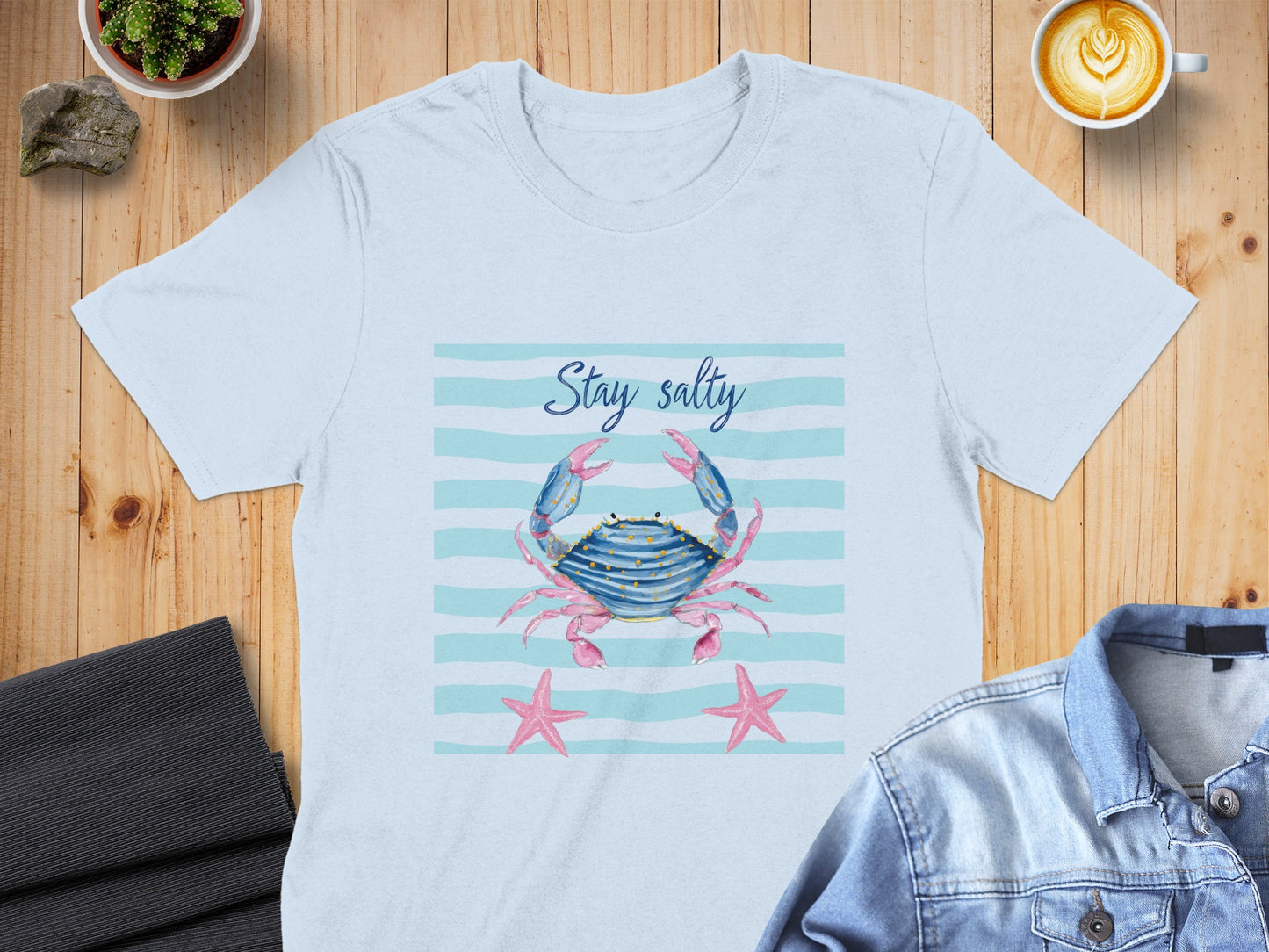 Light blue t-shirt with crab and starfish graphic and "Stay salty" text.
