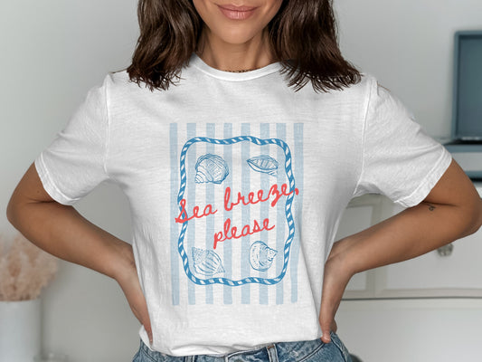 White t-shirt with blue stripes and "Sea breeze please" text surrounded by shells.