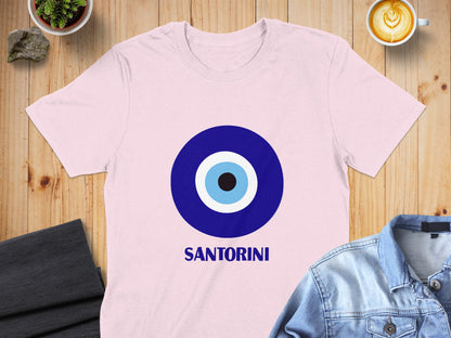 Pink t-shirt with Santorini text and blue and white evil eye graphic.