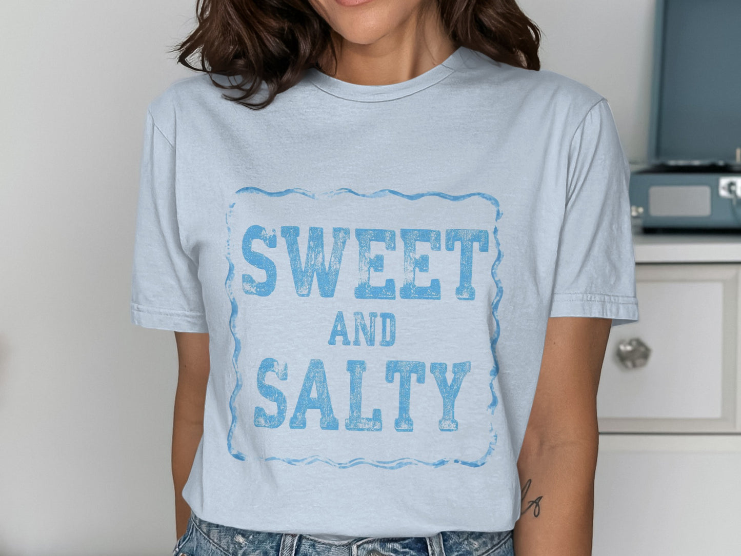 Light blue t-shirt with "SWEET AND SALTY" in distressed blue lettering.