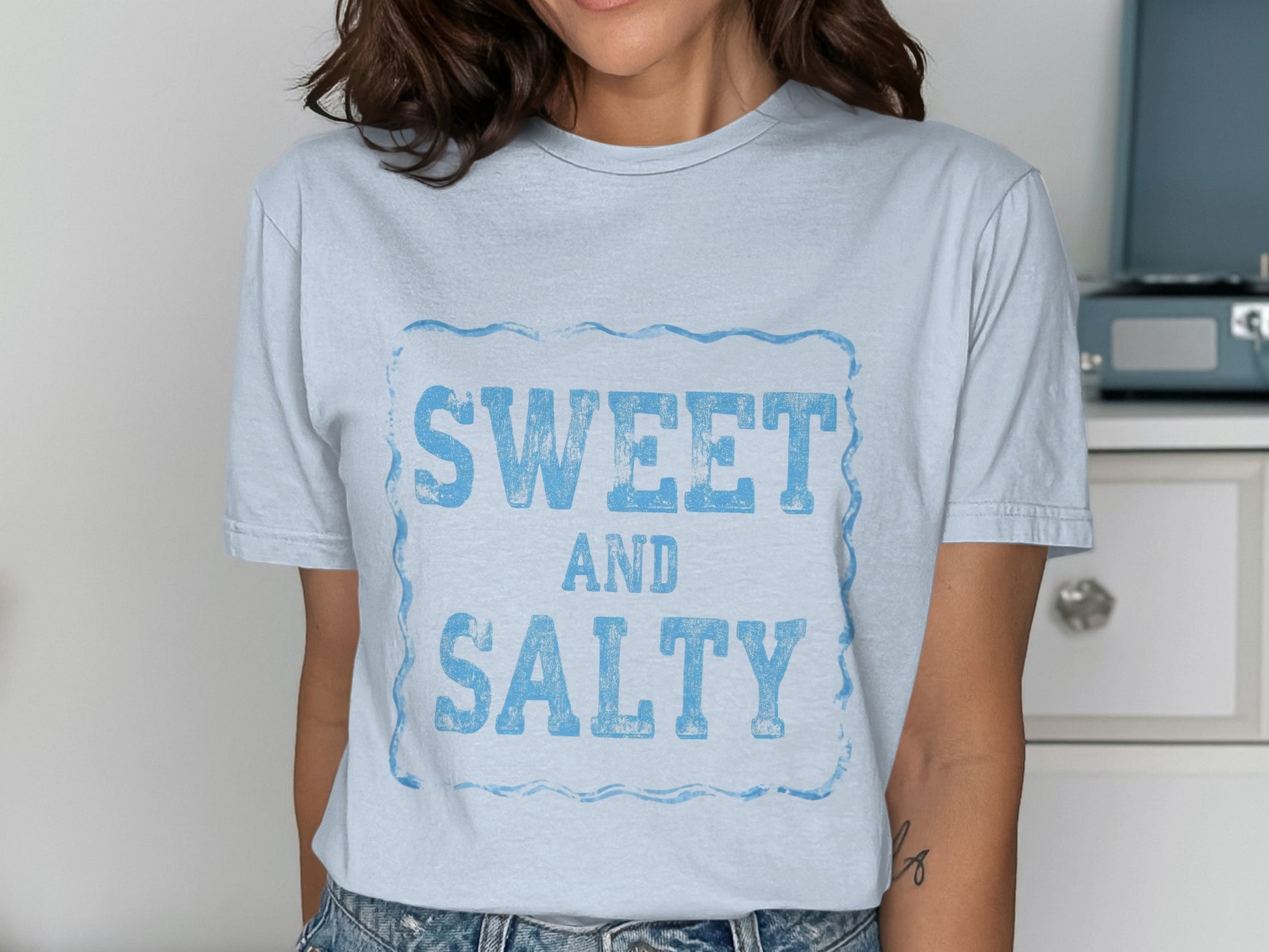 Light blue t-shirt with "SWEET AND SALTY" in distressed blue lettering.