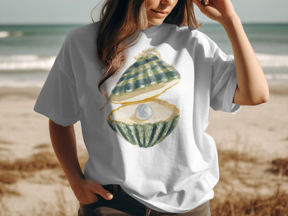 White t-shirt with watercolor painting of an open oyster shell with a pearl.
