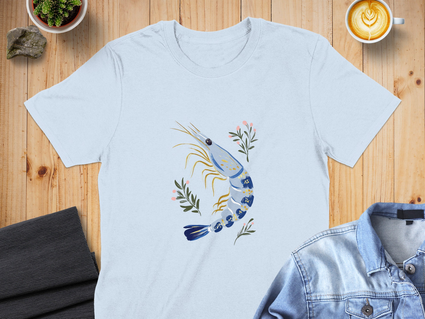 Light blue t-shirt with a blue and white shrimp and floral design.