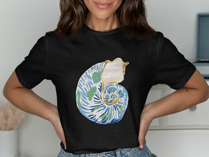 Black t-shirt with a watercolor seashell graphic in blue, green, and gold.