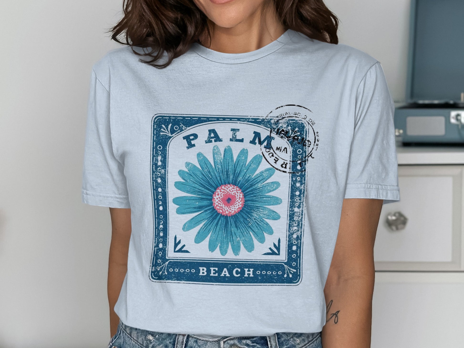 Light blue t-shirt with a blue flower and "Palm Beach" text graphic.