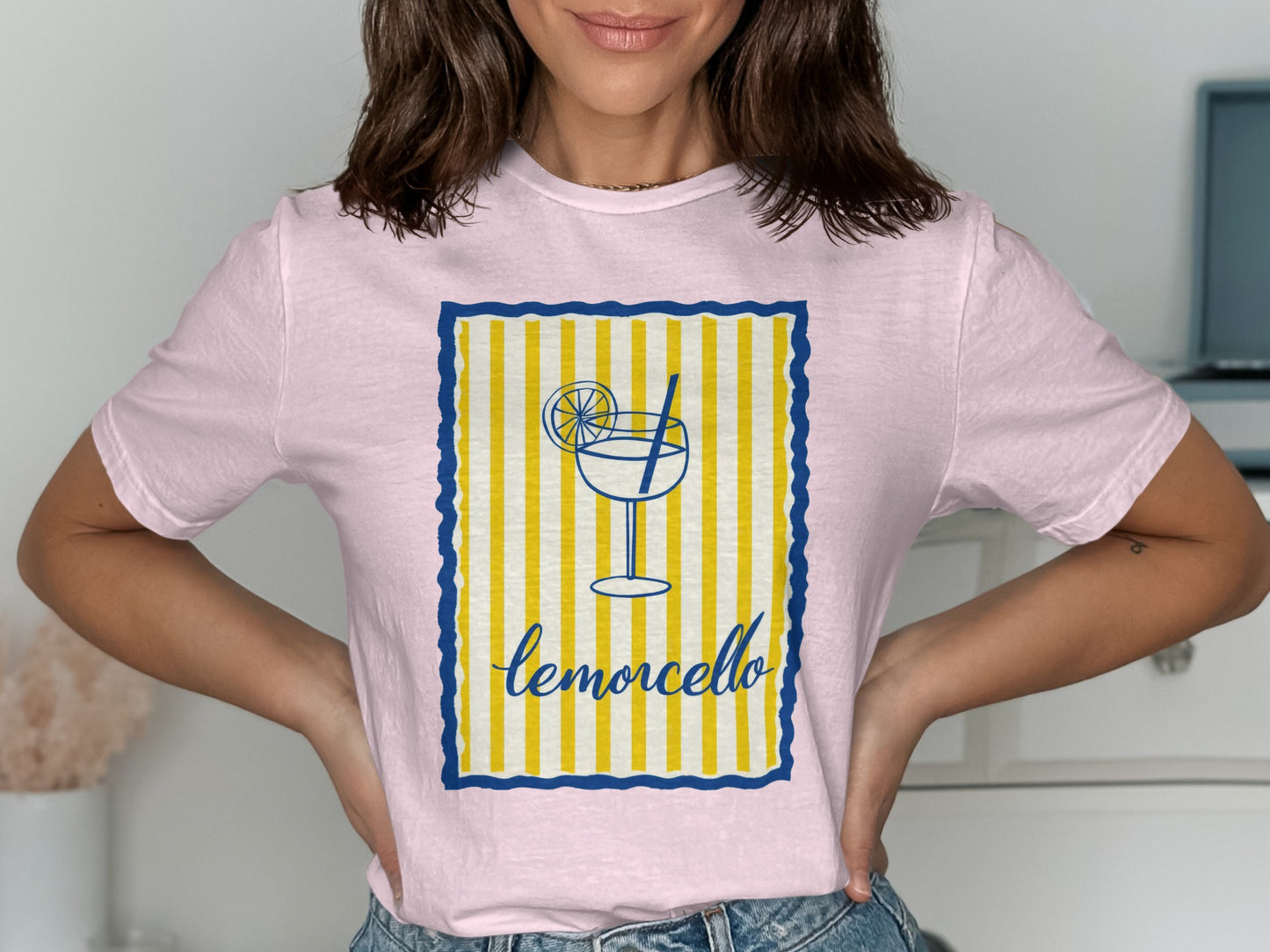 Pink t-shirt with a lemon slice and "limoncello" text in a striped border.