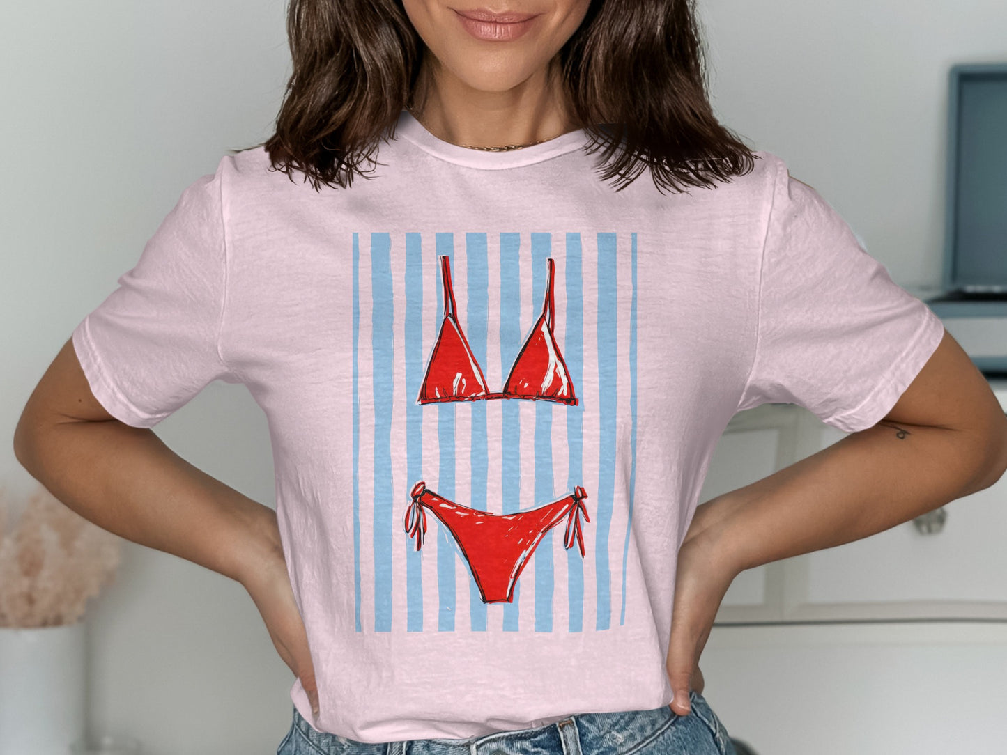Pink t-shirt with a red bikini and blue and white striped background graphic.