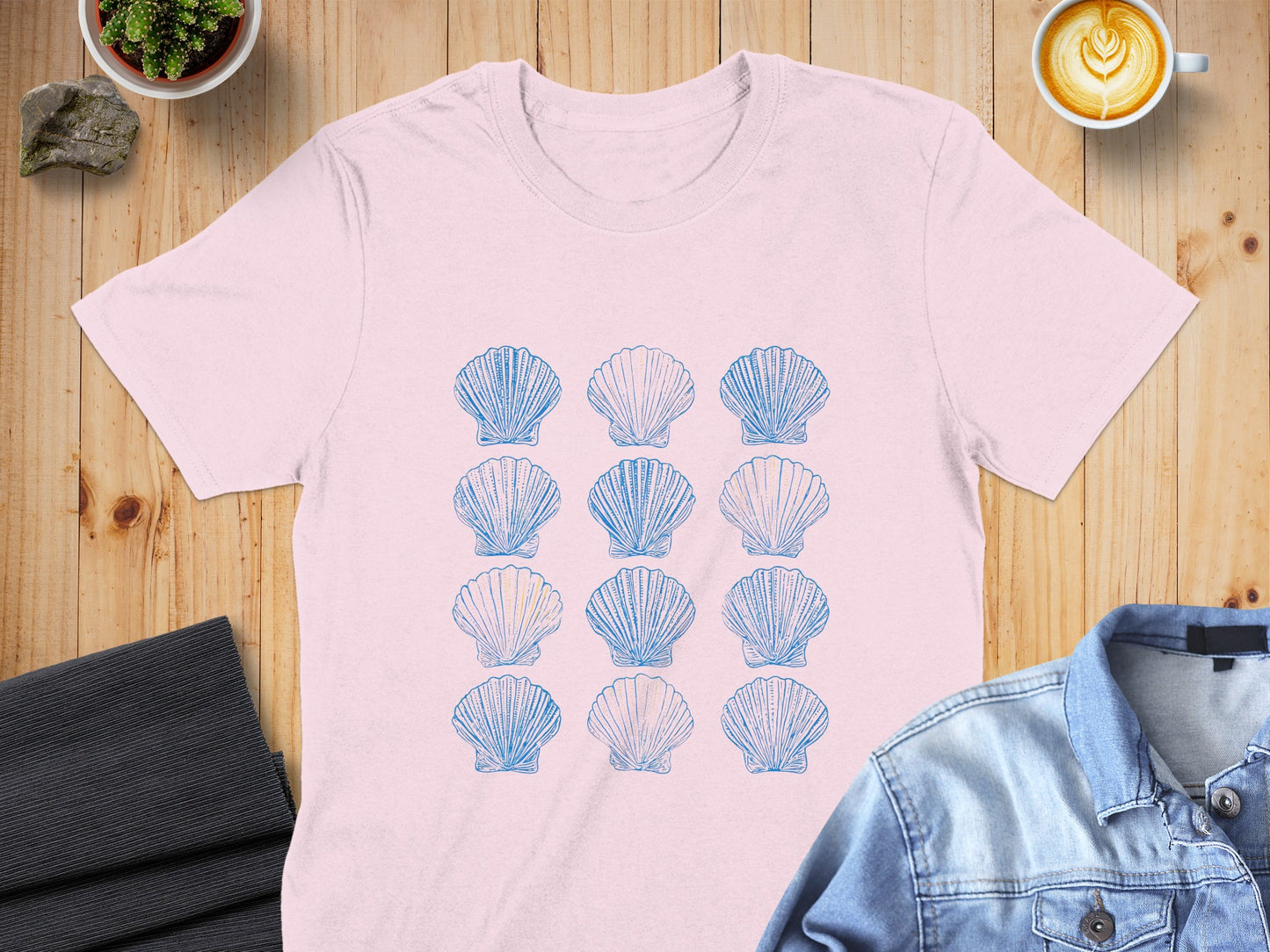 Pink t-shirt with a grid of blue seashell illustrations.
