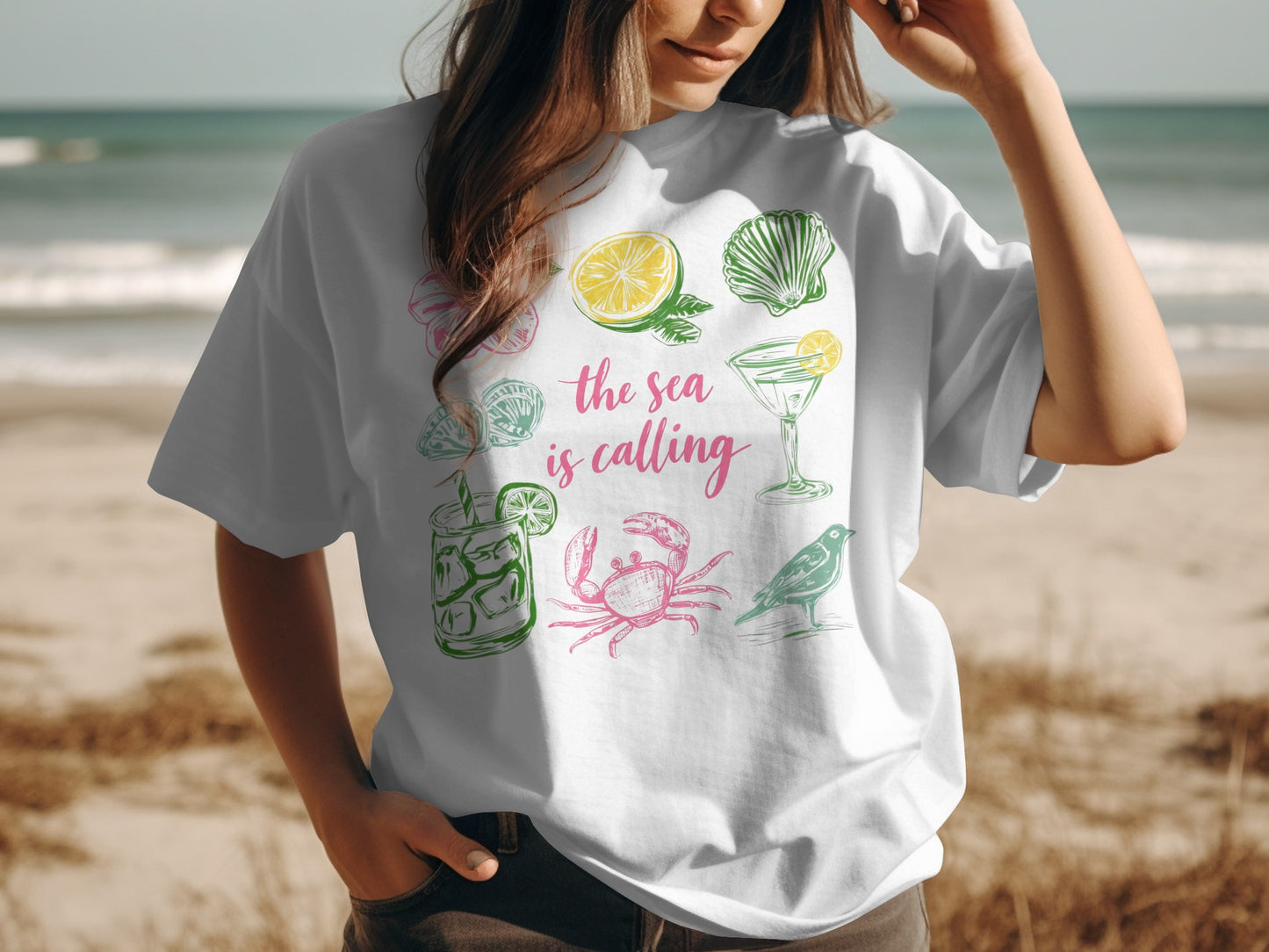 White t-shirt with colorful beach-themed illustrations and text.