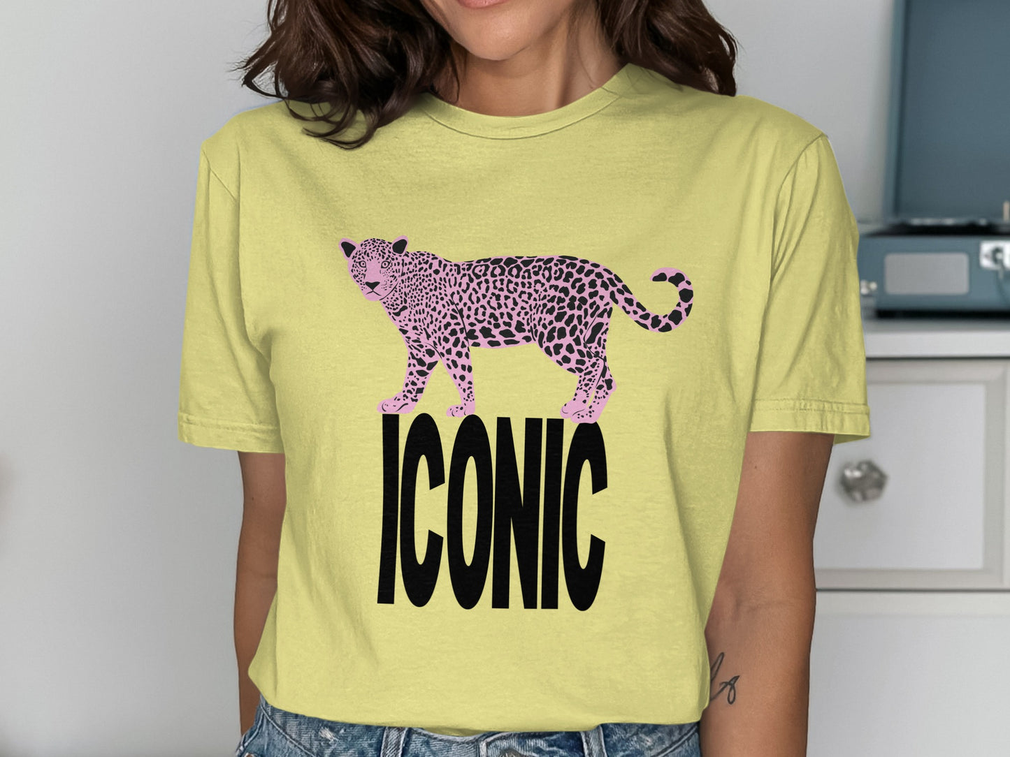 Yellow t-shirt with pink leopard print and black "ICONIC" text.