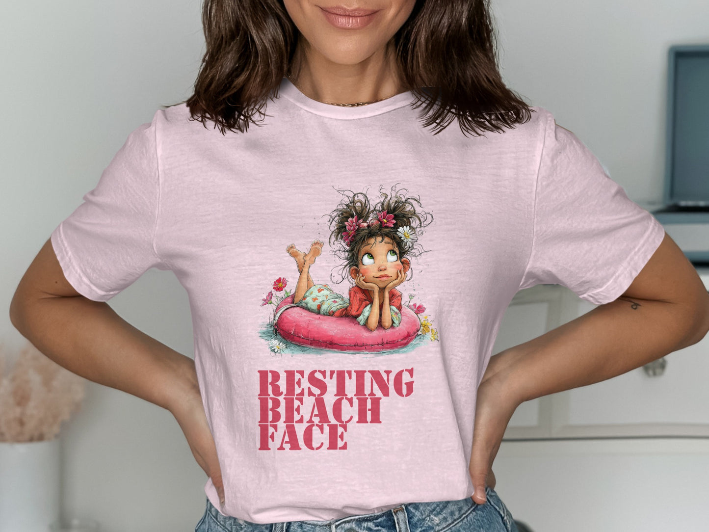 Pink t-shirt with graphic of girl in inflatable ring saying "Resting Beach Face".