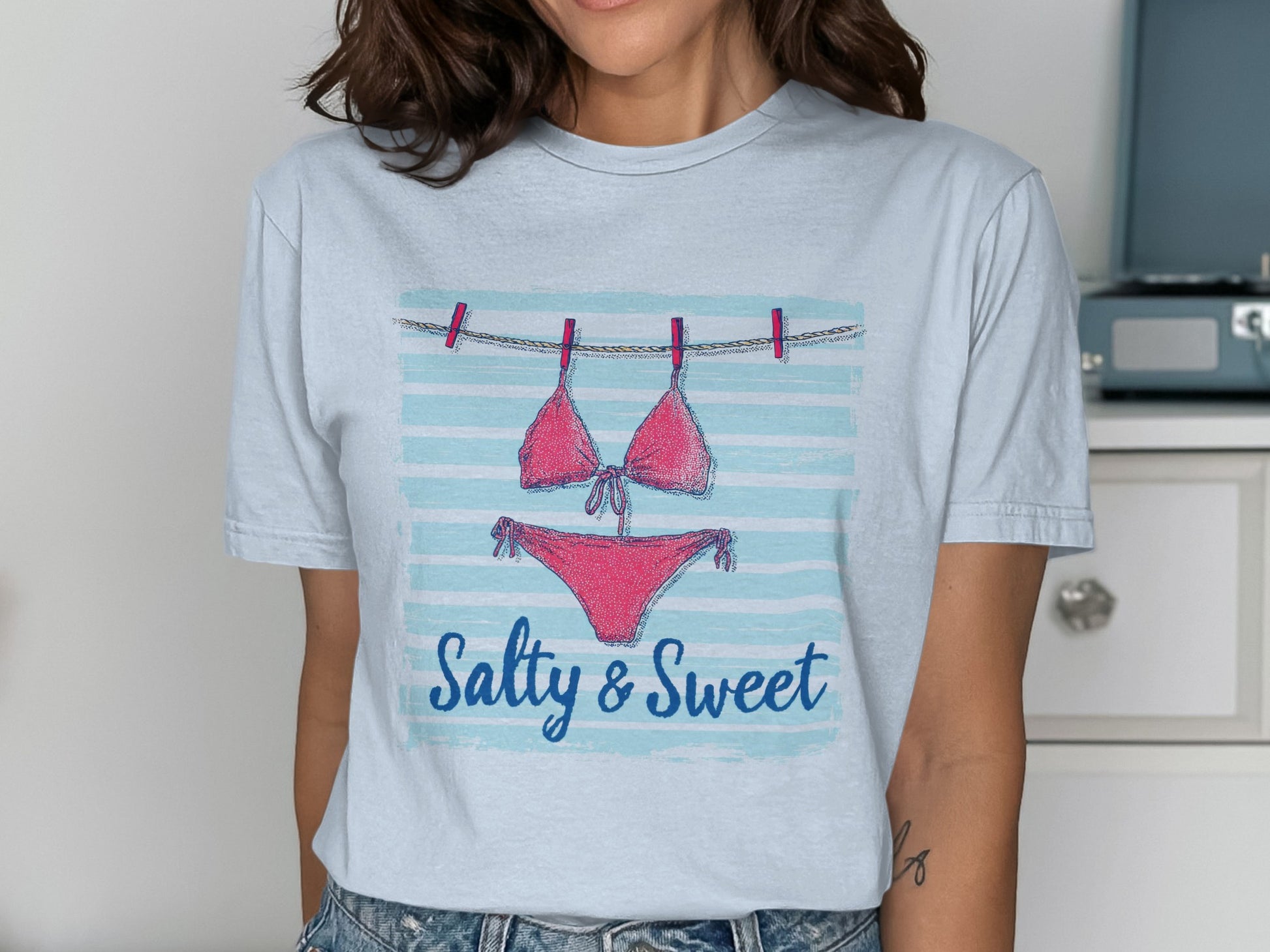 Pink bikini hanging on clothesline with "Salty & Sweet" text.
