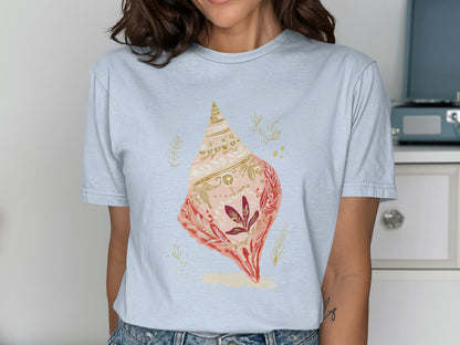 Light blue t-shirt with a large, ornate seashell and floral design.
