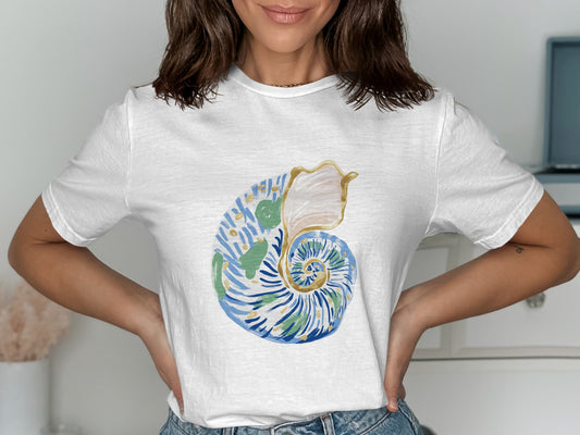 White t-shirt with a blue and gold seashell print.