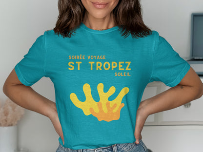 Teal t-shirt with "Soirée Voyage St Tropez Soleil" and abstract yellow and orange coral design.