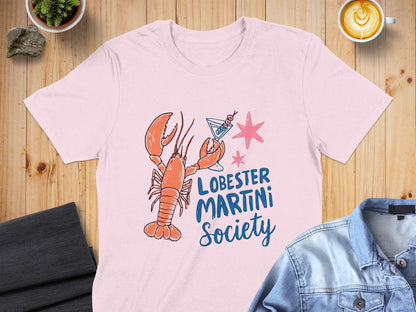 Pink t-shirt with a cartoon lobster holding a martini glass and "LOBESTER MARTINI Society" text.