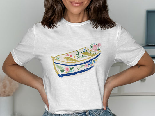 White t-shirt with a colorful floral boat illustration.