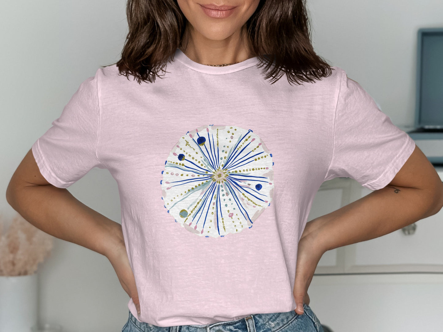 Pink t-shirt with a watercolor-style illustration of a sea urchin.