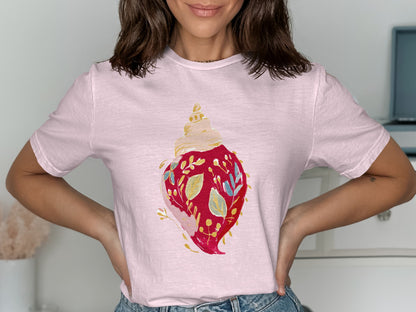 Pink t-shirt with a watercolor illustration of a decorated seashell.