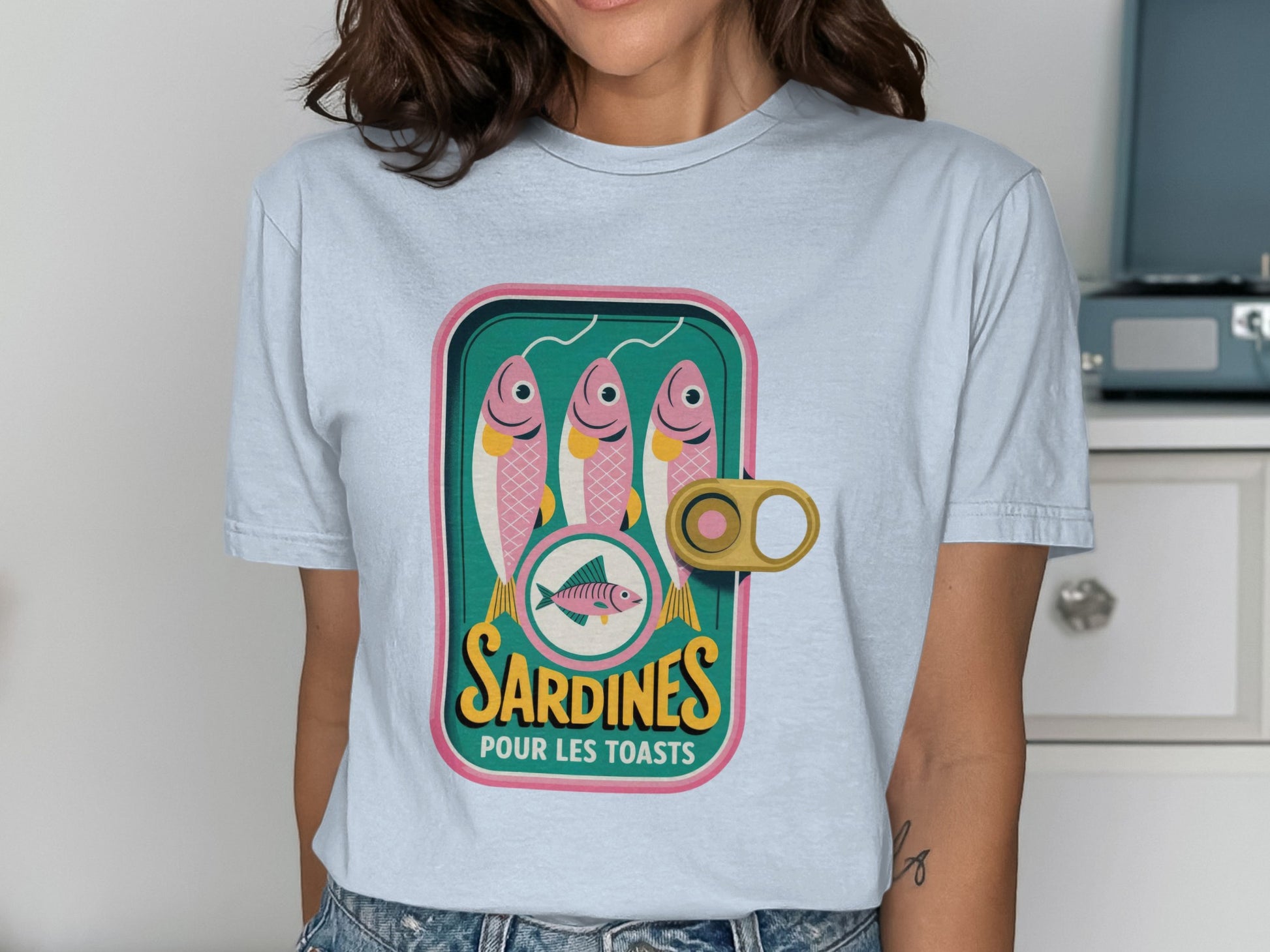 T-shirt with a stylized sardine can illustration reading "Sardines Pour Les Toasts."