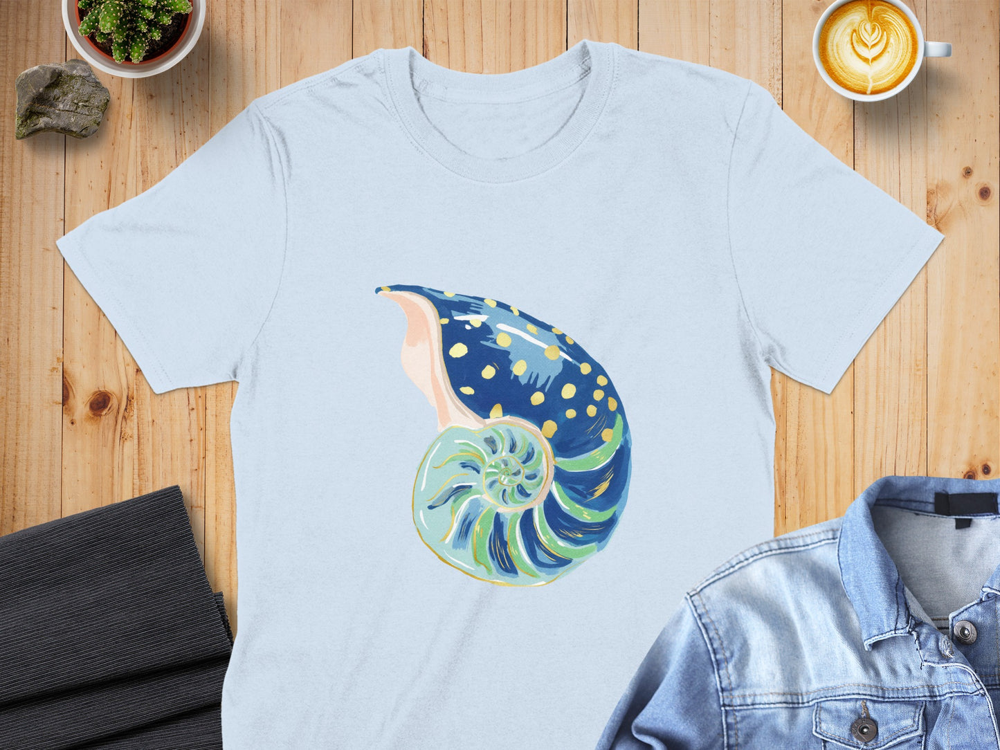 Light blue t-shirt with a painted nautilus shell design.