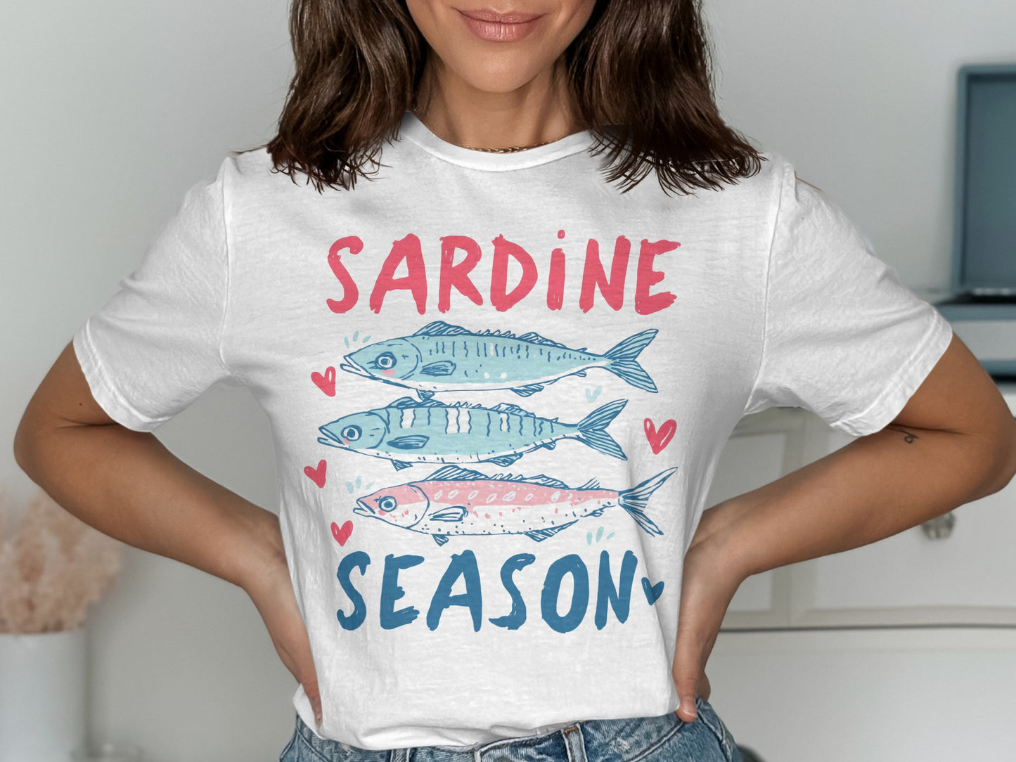 White t-shirt with "Sardine Season" and three colorful sardines graphic.